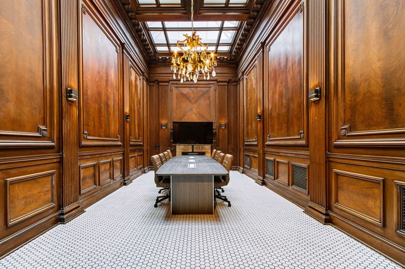 Wood-paneled boardroom with chandelier and skylight